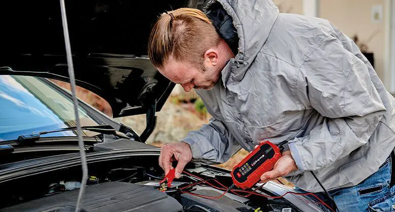 Conducteur vérifiant sa batterie avec chargeur intelligent